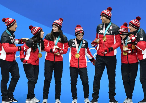 Canada's gold medal-winning team celebrate on the podium during the medal ceremony for the figure skating team event on Feb. 12, 2018.