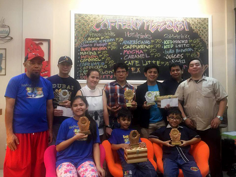 photo shows the winners and organizing committee in the just ended  Coffeekoy Pichakai Executive and Kiddies-Youth Rapid Chess Tournament at the Coffeekoy Pichakai coffee shop, Village East, Executive Homes in Cainta, Rizal on Sunday, January 14, 2018. standing from left: Mr. Bong Buto, Engineer Roy Manaloto of Toshiba Philippines (executive 3rd place), Macel Ventura of  Coffeekoy Pichakai coffee shop, Dr. Alfred Paez (executive champion), DepEd Manager Jason Rojo (executive 2nd place), National Arbiter Alexander Dinoy of CAUP and Sales Director Samivin V. Delos Santos of SM Development Corporation. sitting from left: Rohanisah Buto (Best Female),Al Basher "Basty"Jumangit- Buto (kiddies champion) and Jacob Villaceran (best youngest participant award).