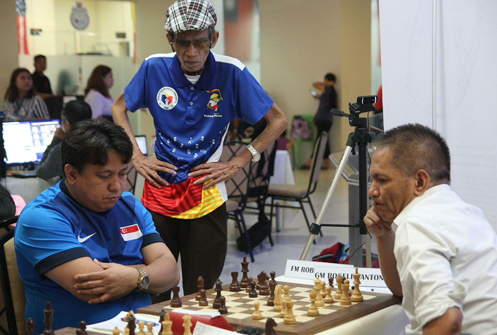 Singapore-based Fide Master Roberto Suelo Jr. (left) ponder his next moves against 13-times Philippine Open champion and second seed Grandmaster Rogelio "Joey" Antonio Jr. (Elo 2452). Looking on is Chief Arbiter IA Gene Poliarco. (Photo by Michaela Concio)