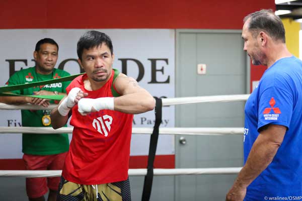 Manny Pacquiao (left) performs a limbering exercise under the watchful eyes of Australian strength and conditioning coach Justin Fortune. PHOTO BY WENDELL ALINEA