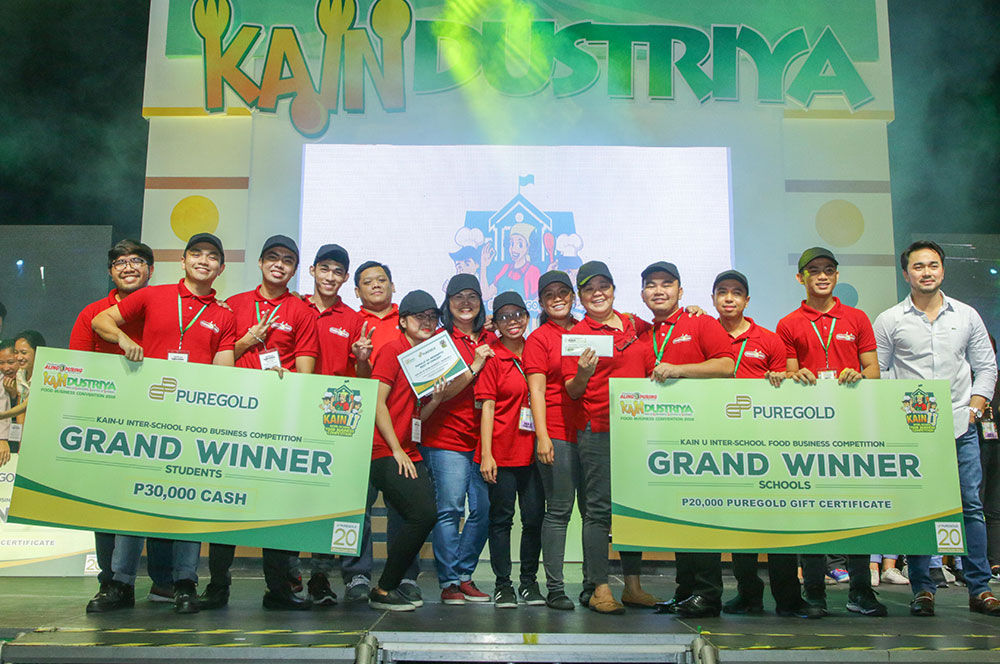 KAINdustriya Council member and KAIN U mentor Prof. Euclid Cezar awards students of Our Lady of Fatima University- Valenzuela. The students bagged KAIN U's Grand Prize with their innovative on-the-go food items of Japanese origin fuzed with Filipino style, the Itadaki Meal.